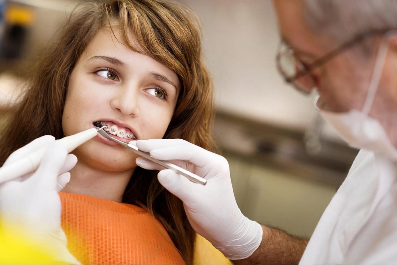 Orthodontist checking a patient's braces and bite alignment in a clinic